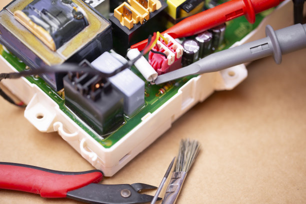 用示波器探头连接到信号测量装置的电子电路板的修理工作。图片下载