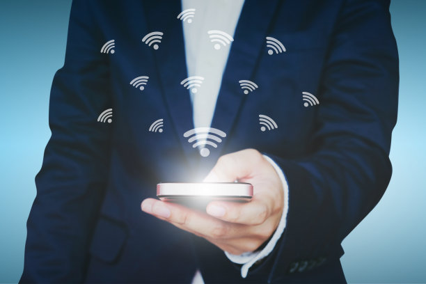 商人拿着带WiFi图标的智能手机。网络技术互联网概念。图片下载