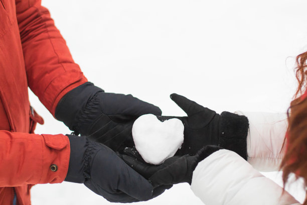 年轻夫妇捧着雪心。戴着手套的手握着冬日里的雪心。爱的概念。圣诞节的背景。新年快乐。选择性聚焦假日-图像情人节背景。——图片图片下载