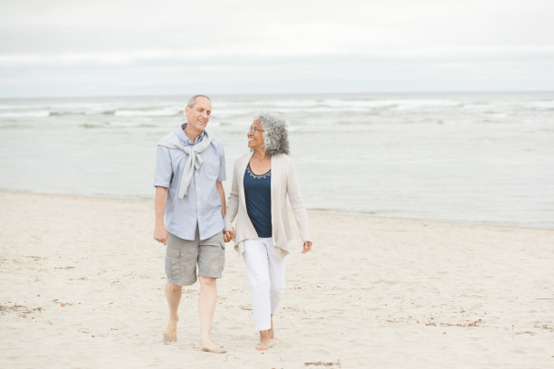 一对老年夫妇在海边手拉手散步图片下载
