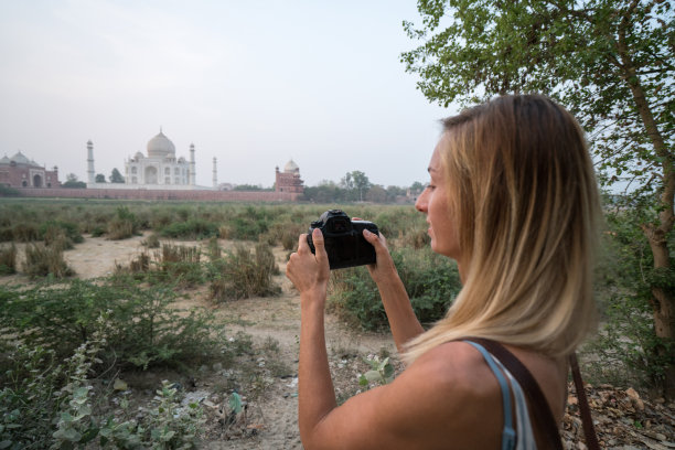 印度阿格拉，游客在日出时用相机拍摄著名的泰姬陵。亚洲人旅游概念图片下载