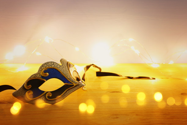 优雅的威尼斯人的照片，狂欢节面具在木桌子和花环黄金灯。图片下载