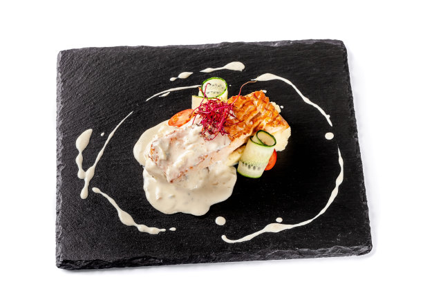 红鱼、鲑鱼或鳟鱼的鱼排，配以土豆泥、圣女果、黄瓜和奶油酱。现代服务在餐厅的黑色石板黑板上。图片下载