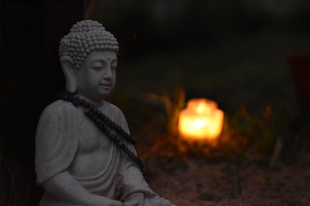 在花园里用金色的烛光冥想佛像图片下载