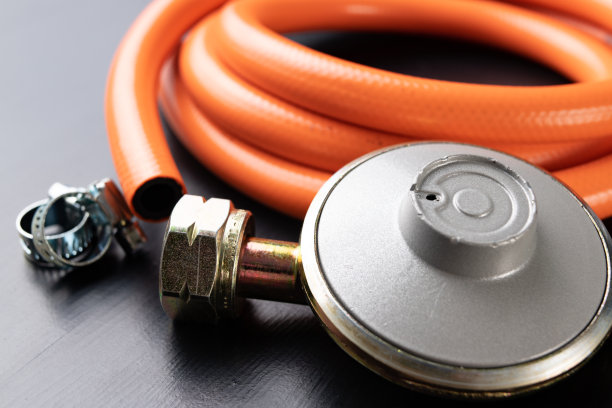 调整器丙烷-丁烷气体钢瓶和附件在一个木制的车间桌子。车间气体附件。图片下载