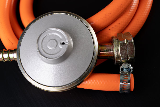 调整器丙烷-丁烷气体钢瓶和附件在一个木制的车间桌子。车间气体附件。图片下载