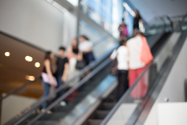 在购物中心的自动扶梯上被人们模糊了图片下载