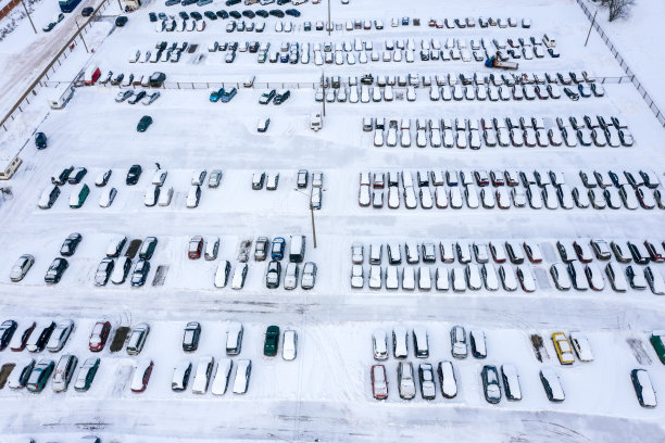 汽车停在冬天的停车场，上面覆盖着雪。无人驾驶飞机的照片图片下载