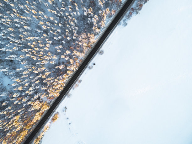 鸟瞰图一辆汽车在冬天的道路在森林。冬天的乡村景观。航拍雪域森林与一辆汽车在道路上。无人机从上面拍下的。航拍照片。车运动图片下载