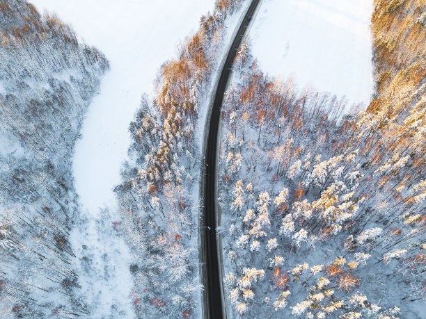 鸟瞰图一辆汽车在冬天的道路在森林。冬天的乡村景观。航拍雪域森林与一辆汽车在道路上。无人机从上面拍下的。航拍照片。车运动图片下载