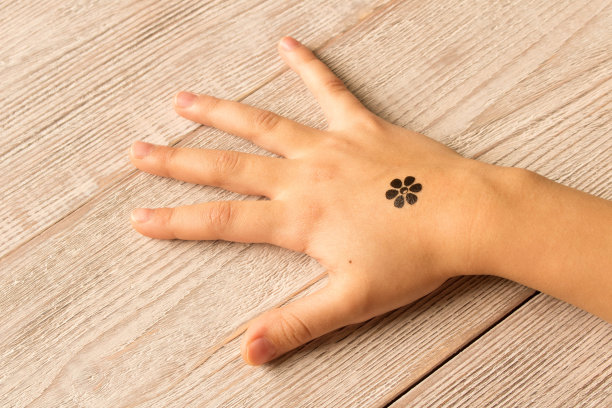 木制背景上有婴儿纹身的小女孩的手掌图片下载