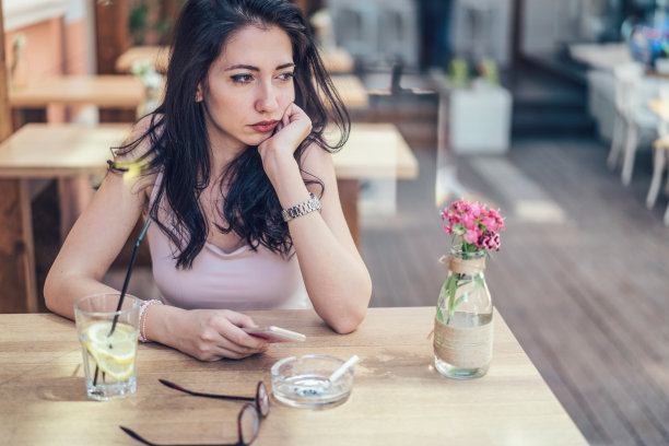 年轻悲伤的女人在café等着图片下载