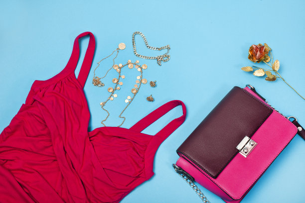 各种时尚配饰:紫红色连衣裙、手袋、黄金首饰、耳环。图片下载