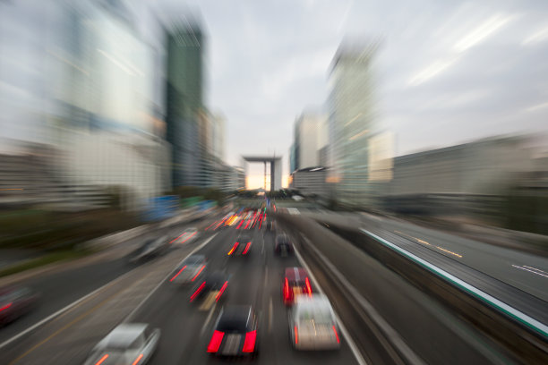 黄昏时分，在城市高速公路上，车辆带着模糊的灯光穿过城市。运动模糊效果。图片下载