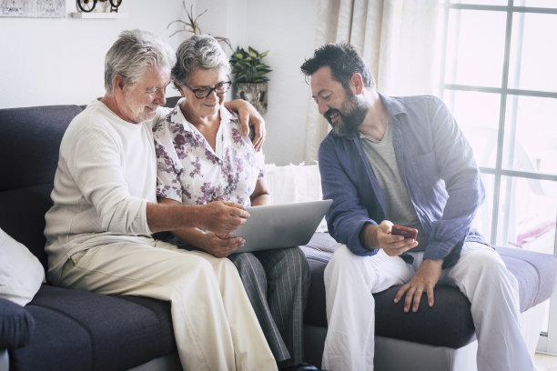白种老年家庭在家里成熟和中年人一起使用技术设备，如笔记本电脑和手机，享受互联网结果-现代男女的日常生活方式图片下载