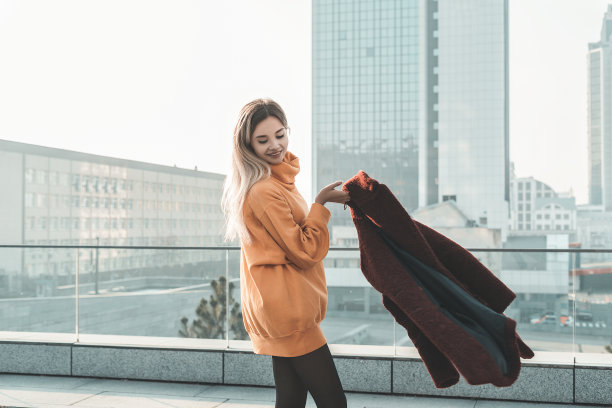 室外大气的生活方式照片年轻美丽的女士。金发碧眼。橙色的毛衣，红色的外套，黑色的连裤袜。温暖的秋天。秋天的氛围。柔软、温暖、舒适图片下载