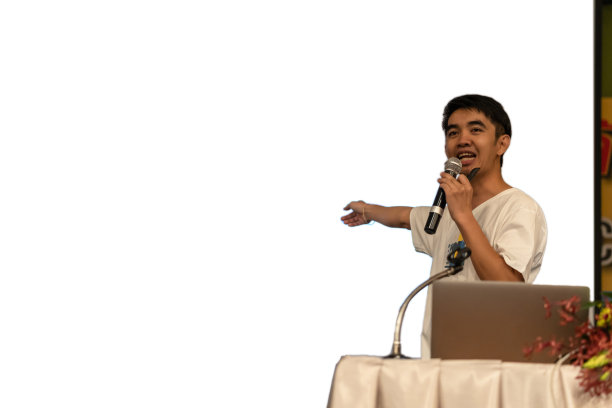 在会议厅或研讨会、商业和教育理念的展示屏幕上，舞台上身着休闲服的亚洲演讲者特写图片下载