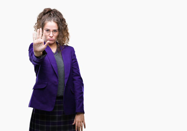 年轻的黑发学生女孩穿着校服和眼镜在孤立的背景做停止唱歌与手掌。警告表情与否定和严肃的手势在脸上。图片下载