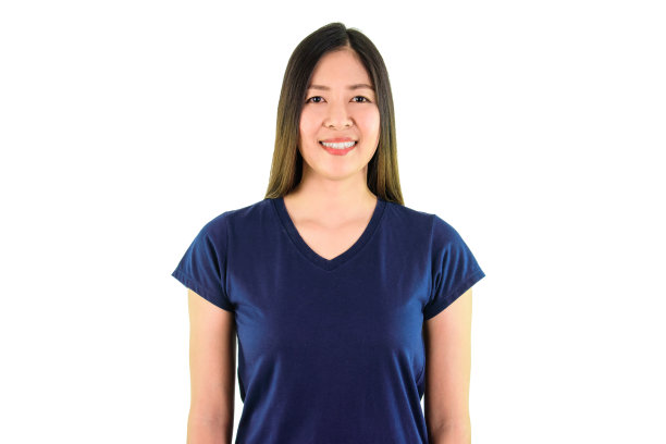 身穿蓝色衬衫的亚洲年轻女子微笑着看着白色背景上的相机。图片下载