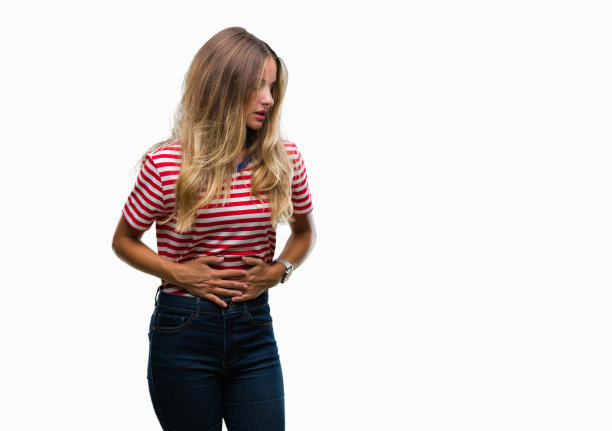 年轻美丽的金发女子过孤立的背景与手胃，因为消化不良，痛苦的疾病感觉不舒服。疼痛的概念。图片下载