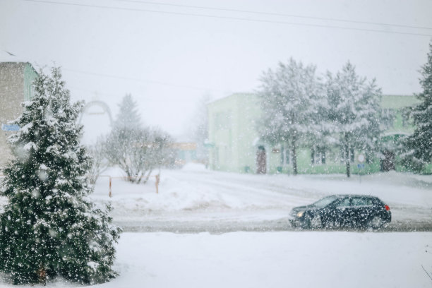 模糊背景的暴风雪，飘落的雪花在冬天的村庄图片下载