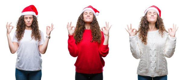 年轻的黑发女孩戴着圣诞帽在孤立的背景放松和微笑闭着眼睛做冥想手势与手指。瑜伽的概念。图片下载