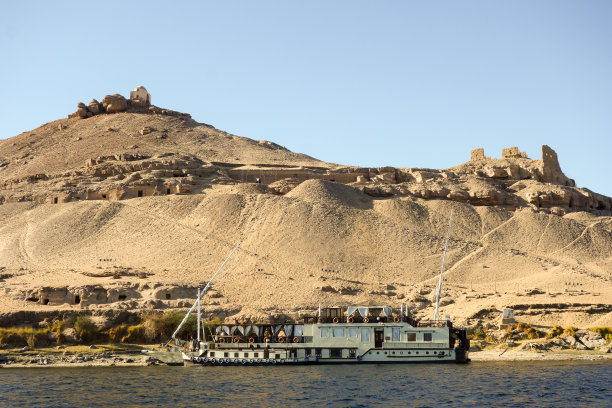 阿斯旺尼罗河上的船只，背后是贵族墓图片下载