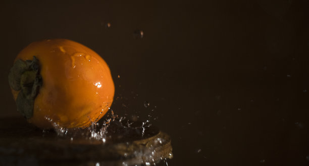 橙色柿子在水里飞溅，暖色调水果人像，农贸市场照片图片下载
