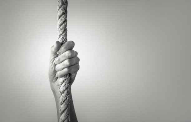 手紧紧抓住绳子。图片下载