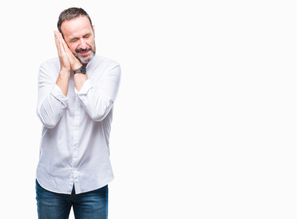 白发苍苍的中年老人在孤立的背景下睡累了，做着梦，摆着合着双手的姿势，闭着眼睛微笑。图片下载