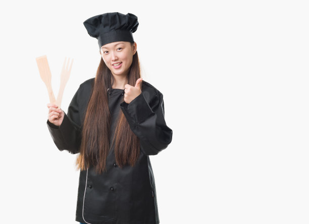 年轻的中国女人在孤立的背景下穿着厨师制服开心地笑着做ok的手势，用手指竖起大拇指，优秀的手势图片下载