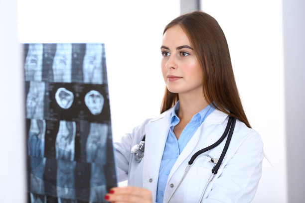 一位女医生站在医院窗户附近检查x光照片。在工作中的外科医生或整形外科医生医疗保健理念图片下载