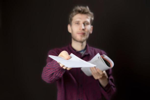 年轻微笑的男性快递员递送白皮书、文件和信件图片下载