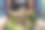 一个蹒跚学步的男孩赤脚坐在绿色的草地上玩泥巴的特写图片下载