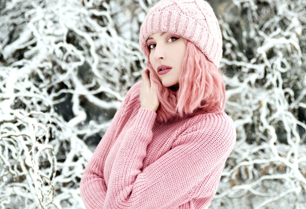 穿着粉红色毛衣和帽子的女人在户外图片下载