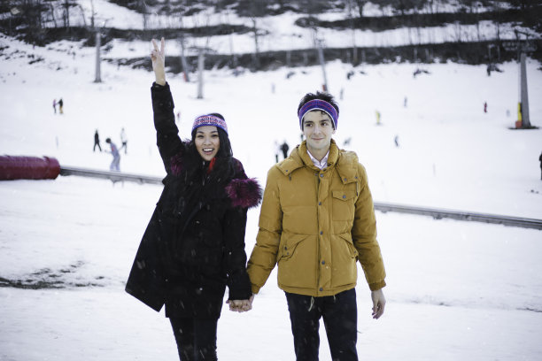 国际快乐青年夫妇在冬天的雪地上漫步图片下载
