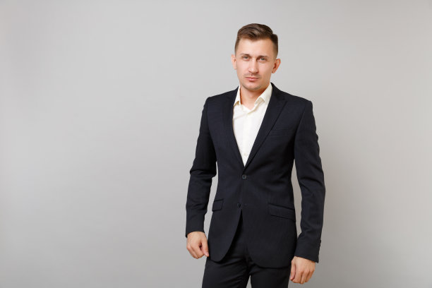 肖像英俊自信的年轻商人在经典的黑色西装白衬衫站在灰色的墙壁背景在工作室孤立。成就事业财富经营理念。模拟拷贝空间。图片下载