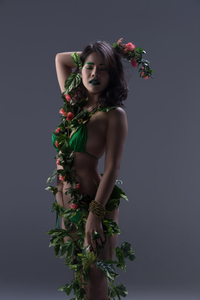 女人用鲜花和绿叶藤蔓装饰身体，性感的情感。图片下载