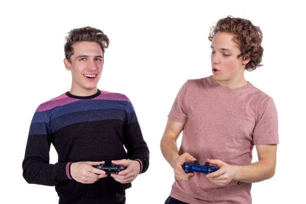 两个年轻的朋友拿着游戏手柄玩电子游戏。锦标赛或锦标赛概念图片下载