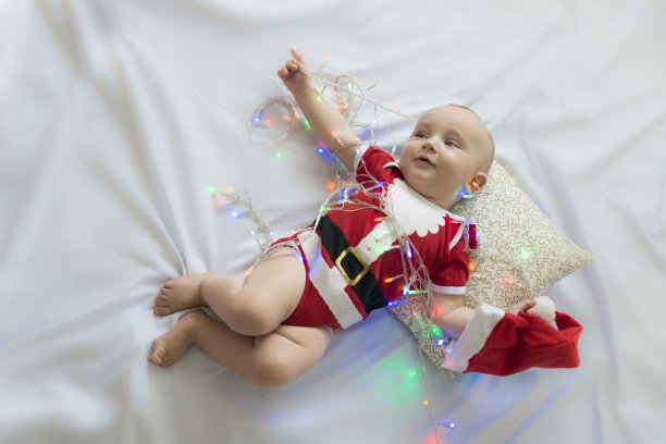 圣诞老人装扮的小男孩躺在床上图片下载