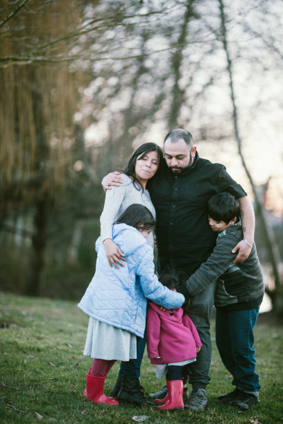 年轻的西班牙家庭在公园里集体拥抱图片下载