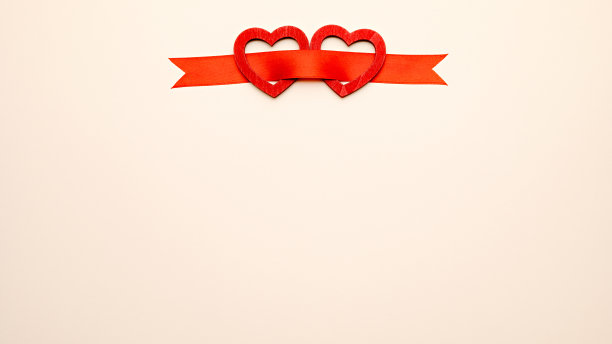 两颗带红丝带的木心。情人节的背景图片下载