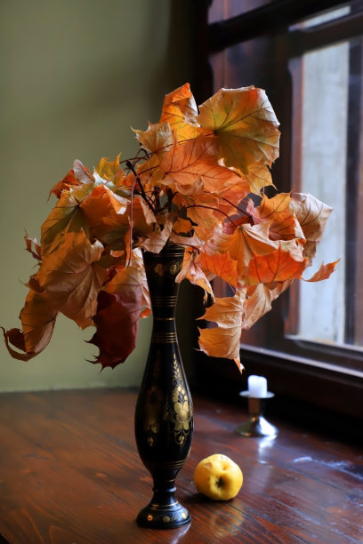干枯的枫叶放在靠近窗户的花瓶里。图片下载