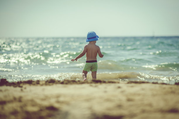 快乐的男孩在沙滩上玩耍图片下载