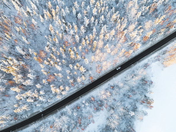 鸟瞰图一辆汽车在冬天的道路在森林。冬天的乡村景观。航拍雪域森林与一辆汽车在道路上。无人机从上面拍下的。航拍照片。车运动图片下载