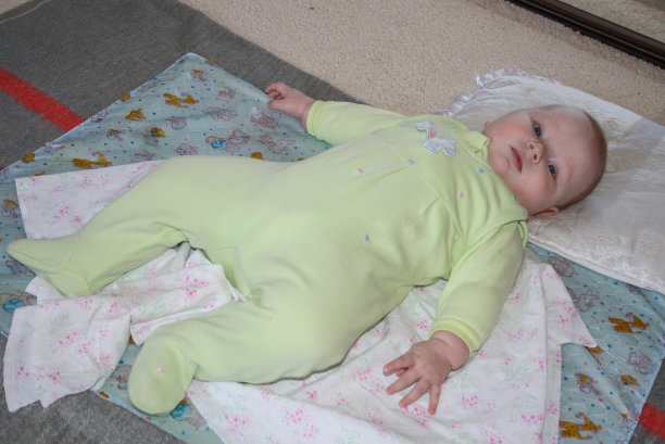 一个小男孩躺在地板上，看着镜头。图片下载