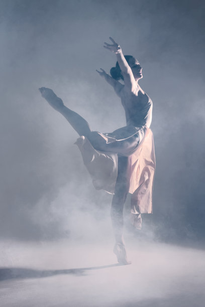 在孤立的背景上，优雅的芭蕾舞女演员在烟雾中跳舞图片下载