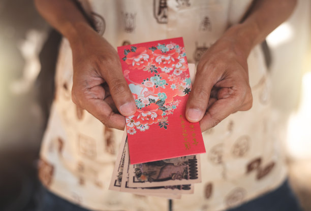 近距离拍摄亚洲华人在中国新年拿着红包送红包图片下载