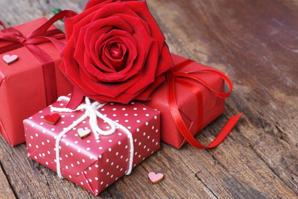 木桌背景上一组可爱的盛开的红色玫瑰花，点缀迷你红色心形图案，甜蜜情人礼物概念，复制空间图片下载