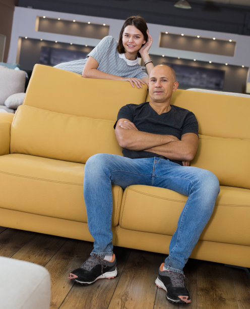 一对夫妇坐在黄色的沙发上图片下载